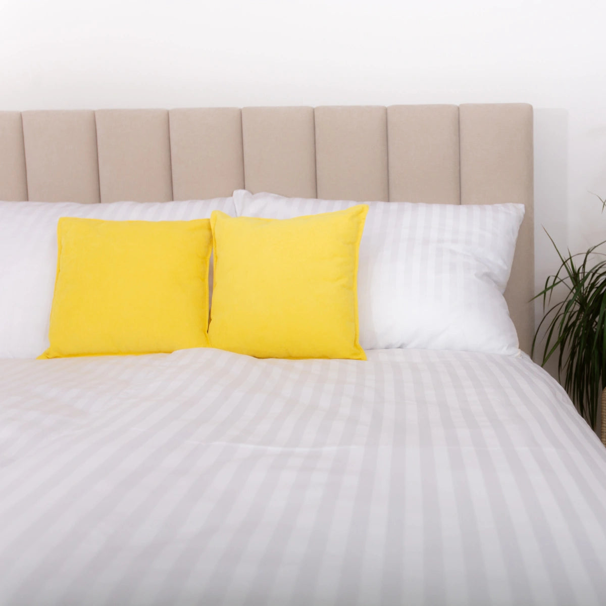 Luxusné biele damaskové obliečky Azonelo Elegance zo 100% bavlny, vyrobené na Slovensku. Elegantný dizajn s jemným leskom na ustlanej posteli so žltými dekoračnými vankúšmi.