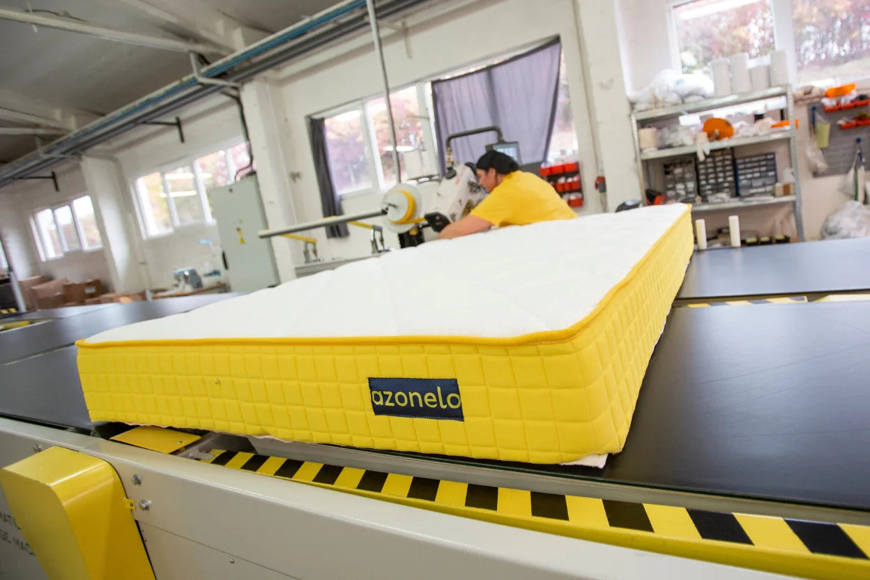 Naša špecialistka na špičkovom stroji ručne dokončuje slovenske matrace Azonelo precíznym našívaním žltej lemovky.