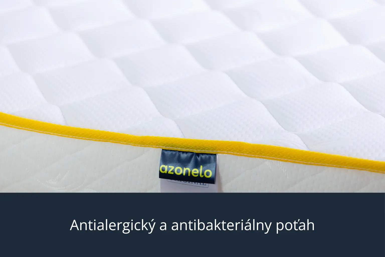 Detailný záber na čistý biely poťah s moderným žltým lemovaním a látkovou nášivkou s logom Azonelo. Materiál je mäkký na dotyk, priedušný a upravený tak, aby bol vhodný pre alergikov.