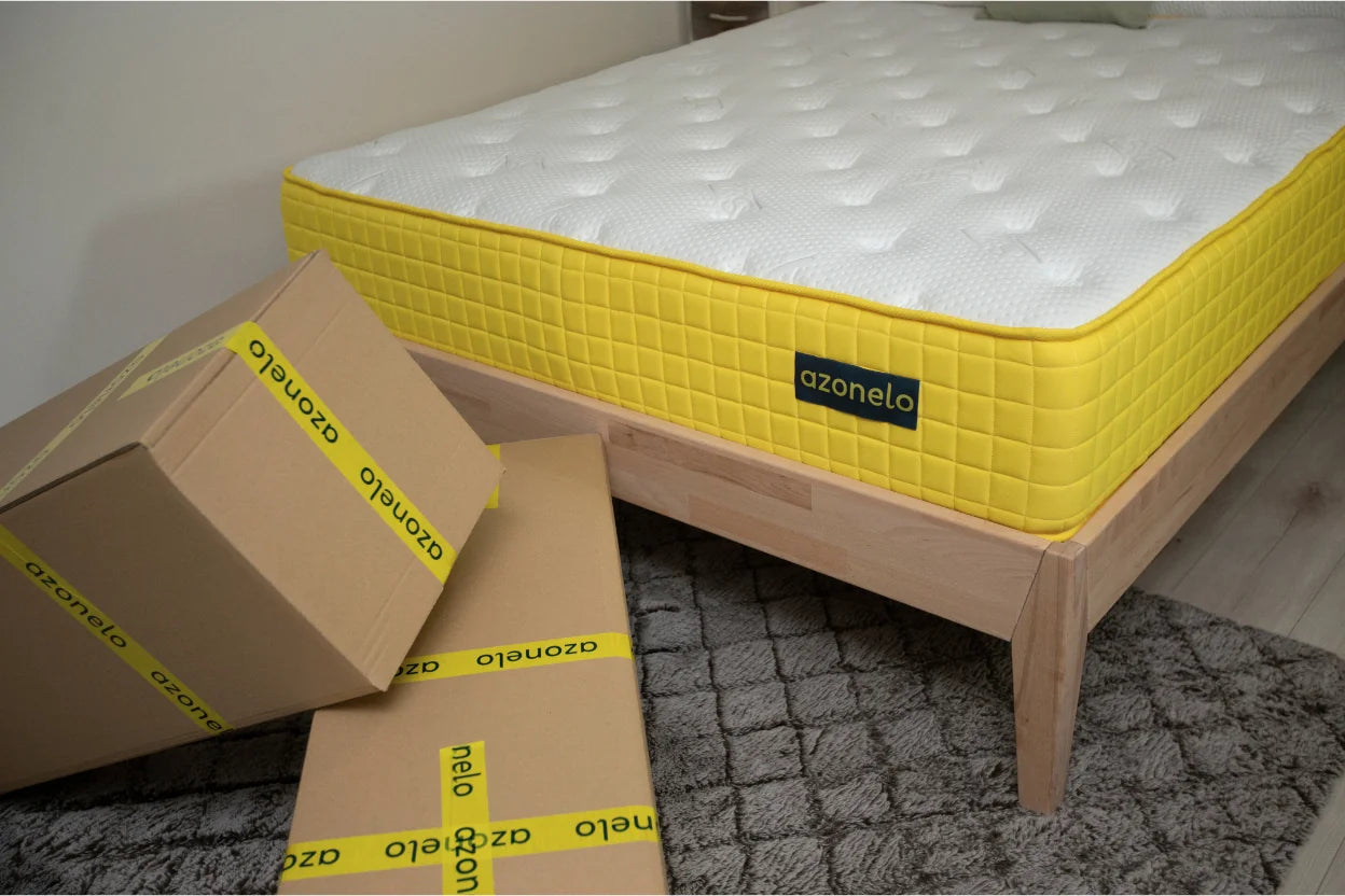 Vysoký matrac Azonelo Cloud po rozbalení na drevenej posteli, s krabicami od doručenia v popredí.