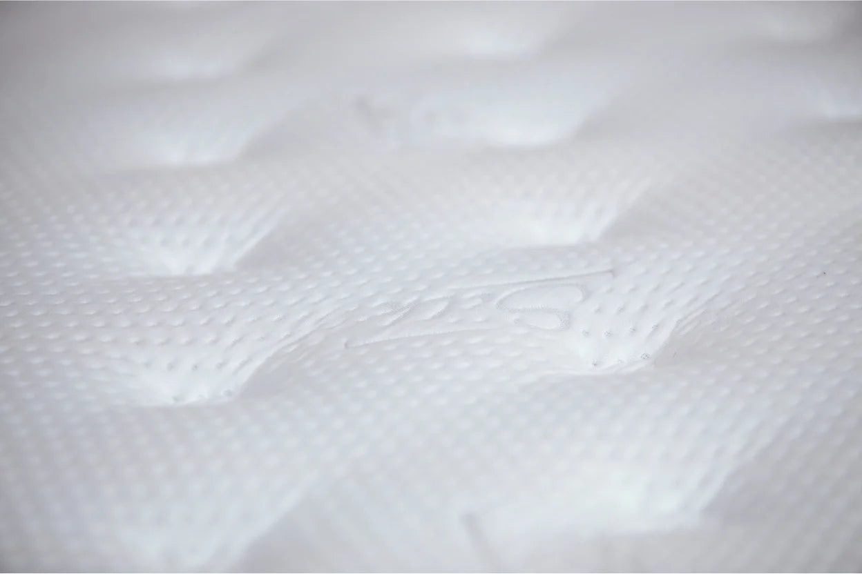Detailný záber na kvalitný biely poťah, aký používame pre naše slovenské matrace. Jemná prešívaná textúra.