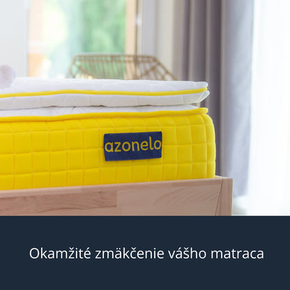 Pripravený 4 cm hrubý vrchný matrac Azonelo Dream zo špičkovej pamäťovej peny uložený na žltom matraci v presvetlenej spálni, odborne navrhnutý na dokonalé zmäkčenie vášho aktuálneho lôžka.