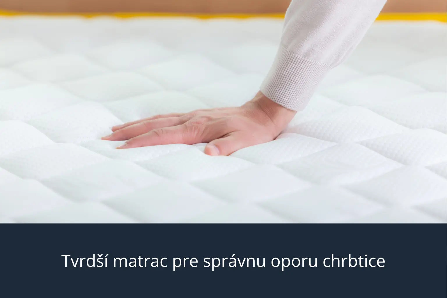 ohľad zblízka na ruku, ktorá zatláča do bieleho prešívaného matraca Azonelo Original. Obrázok ukazuje, že matrac je príjemne pevný, neprehýba sa a poskytuje spoľahlivú oporu pre chrbticu.